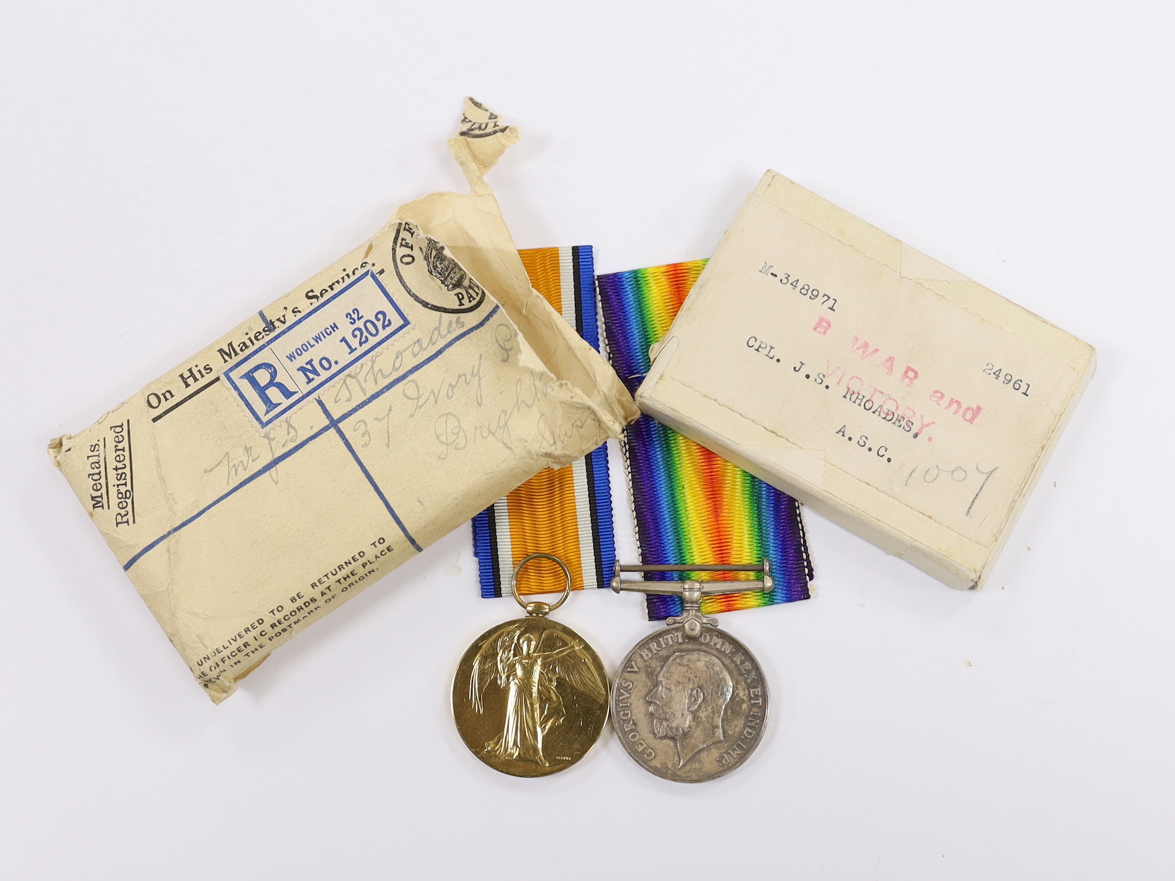 A WWI medal pair of Victory medal and British War medal, to Cpl. J.S. Rhodes A.S.C., with their original card box and outer postal envelope